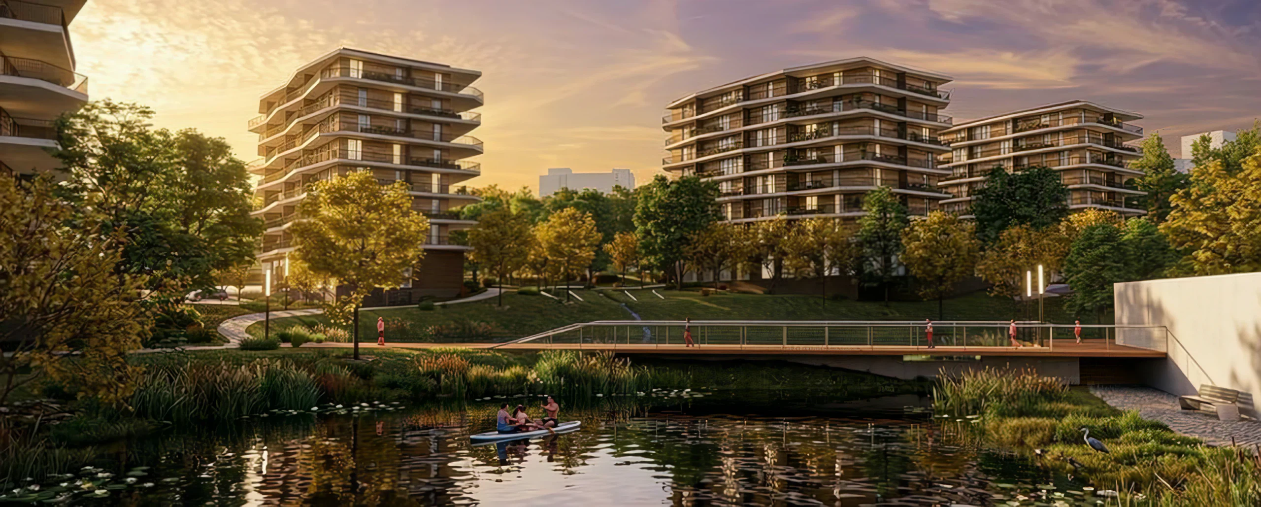 Travelling sobre o lago ao pôr do sol, com a ponte pedonal a atravessar para os edifícios de habitação.